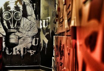 CRU Bar Lisbon: Graffiti art featuring a gas mask on a wall. Gay travel advice for Lisbon's nightlife scene. Cool decor, CRU gay bar.