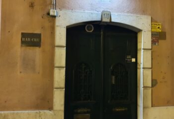 Entrance to Bar CRU in Lisbon. Dark doors with stone frame. Gay travel advice for Lisbon.