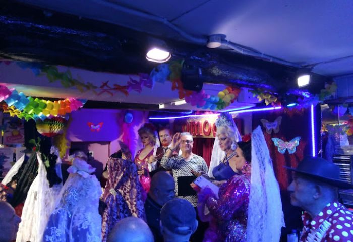 Comodin Gay Bar in Sitges: Drag queens perform on stage at this popular gay bar. Rainbow decorations adorn the venue. Gay travel advice.