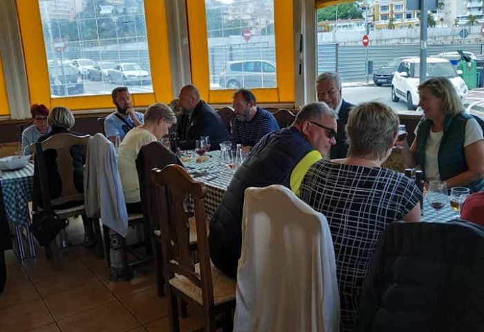 People dine at Bar Babel, a gay bar in Torremolinos. The restaurant has checkered tablecloths and a view of the city.