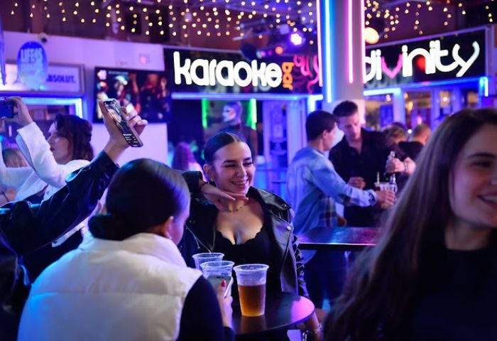 Divinity Gay Bar in Gran Canaria. People drinking, taking pictures, and enjoying the karaoke in this popular gay bar.
