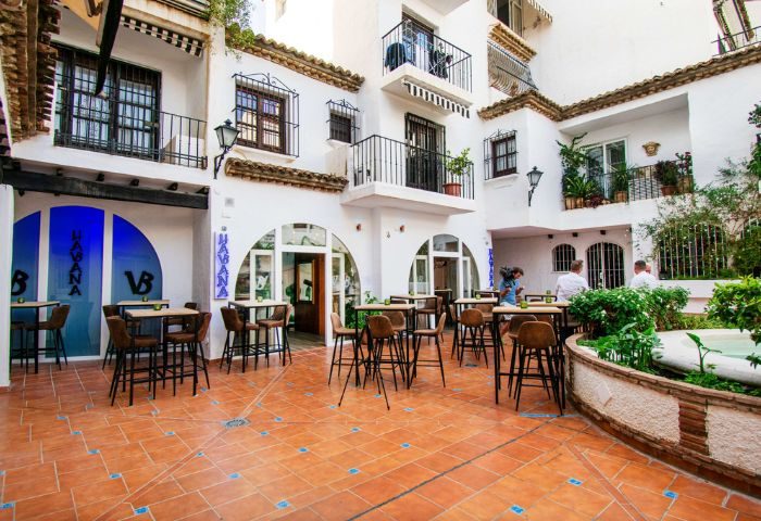Havana Gay Bar in Torremolinos, Spain. Outdoor seating area with tables and chairs in a courtyard setting. Gay travel destination.