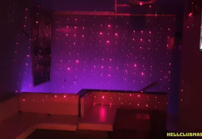 Interior of Hell Bar, a gay cruising club in Gran Canaria. Purple and red lights illuminate the space, creating a fetish-friendly atmosphere.