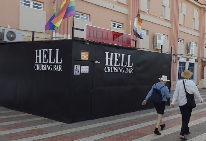 Gran Canaria gay cruise club: Hell Cruising Bar exterior, flags, and people walking by. Gay travel advice, fetish scene.