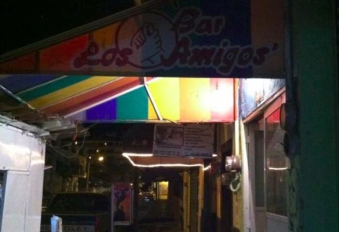 Entrance to Bar Los Amigos, a gay bar in Puerto Vallarta. Rainbow flag colors adorn the awning. Nightlife scene for gay men travelers.