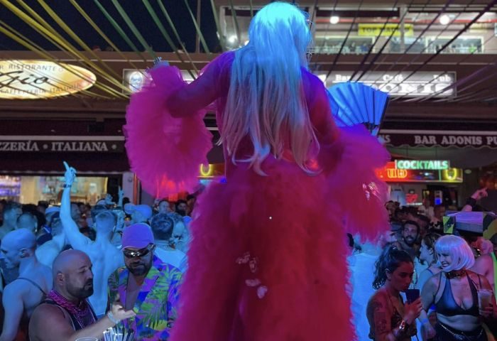 Drag queen performing at Peppermint Gay Bar in Gran Canaria. Nightlife scene with a lively crowd. Gay travel destination.