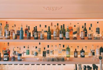 Bar Renard in Montreal: Well-stocked bar shelves with diverse liquor bottles, glasses, and bar equipment. Gay travel nightlife.