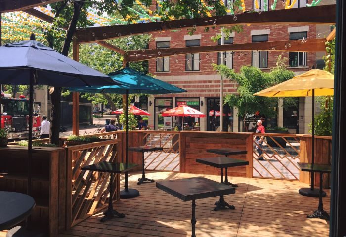 Outdoor patio at Bar Renard in Montreal. Tables with umbrellas. Gay travel advice. Montreal's gay village.