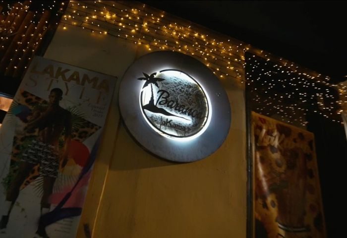 Baranoa Gay Bar in Madrid sign. Round sign with palm tree logo. Gay travel destination. Nightlife spot. Lit sign. Gay bar travel.