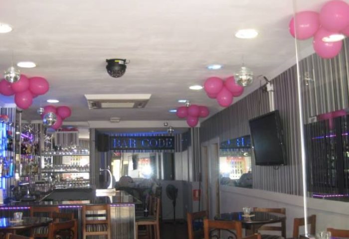 Interior of Barcode Gay Bar in Benidorm, Spain. Pink balloons, disco balls, and a well-stocked bar. Gay travel destination.