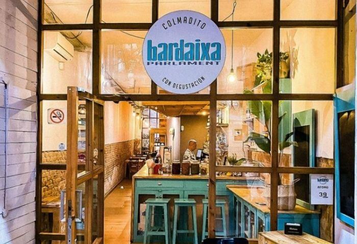 Bardaixa Gay Bar in Barcelona. View of the bar's interior through the window. A cozy space for gay travelers to enjoy drinks and company.