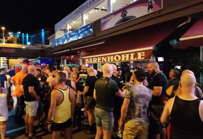 Bärenhöhle Bear Cave gay bar in Gran Canaria. A crowd of men gather outside the popular gay bar, enjoying the nightlife scene.