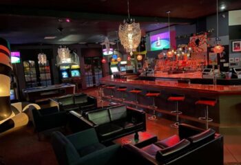 Interior of Bart Lounge, a gay bar. Features include a bar, seating, pool table, arcade games, and TVs. Good for gay men travel advice.