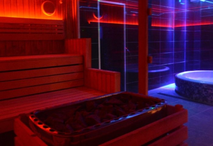 Sauna & jacuzzi at Basement Complex, Manchester. Gay travel advice for relaxing in style. Red & blue neon lights.