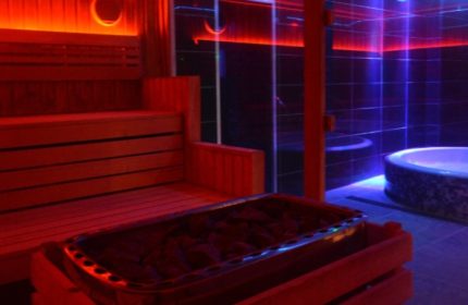 Sauna & jacuzzi at Basement Complex, Manchester. Gay travel advice for relaxing in style. Red & blue neon lights.