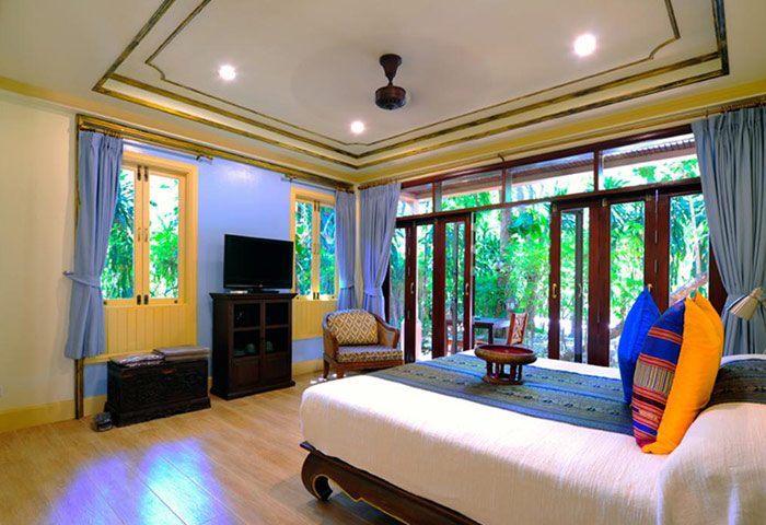 Rabbit Resort Pattaya Thai-style room. Gay hotel with bed, TV, and lush outdoor view. Comfortable, stylish gay travel accommodation.