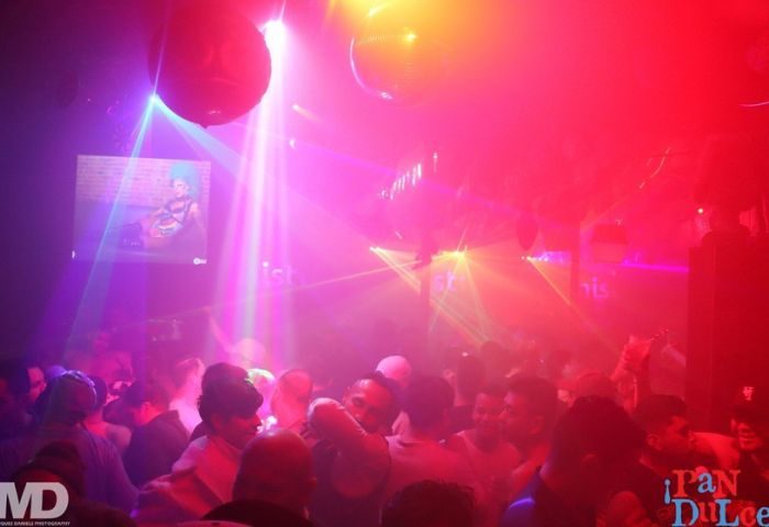 Beaux Gay Bar in San Francisco: A crowded dance floor with disco balls and colorful lights. Gay men enjoying a night out. Nightlife scene.