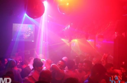 Beaux Gay Bar in San Francisco: A crowded dance floor with disco balls and colorful lights. Gay men enjoying a night out. Nightlife scene.