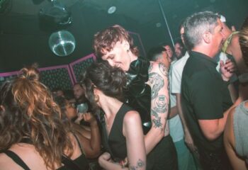 Barcelona's Believe Club: A vibrant gay club scene. People dancing under disco ball, tattoos visible. Nightlife, travel advice.