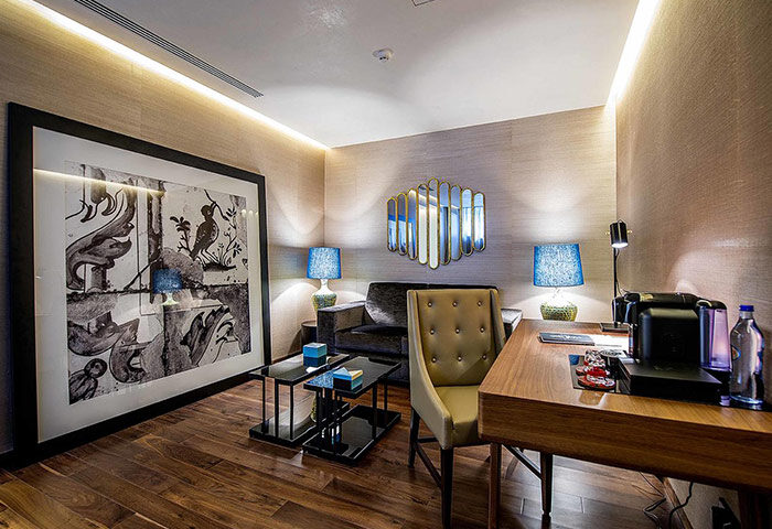 BessaHotel Liberdade Lisbon room. Popular gay honeymoon hotel with desk, chair, art, lamps, and coffee machine. Gay travel advice.