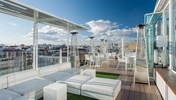 Room Mate Oscar: Madrid gay hotel rooftop pool with city view. Lounge seating, tables, and heaters on the terrace. Best gayborhood spot.
