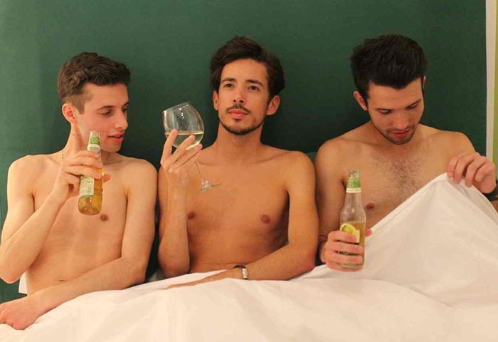 My Rainbow Rooms Gay Men's Guest House: Three shirtless men in bed, drinking beer and wine. Adults-only gay hotel in Lisbon, Portugal.