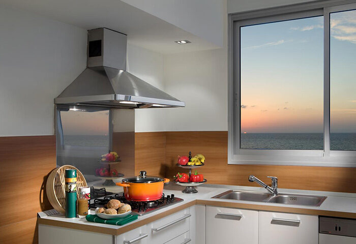 Alexander Tel Aviv Hotel kitchen. Beachfront view from window. Best gay hotel near gay bars. Modern interior, cooking pot on stove.