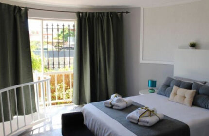 Pasion Tropical Gay Resort room in Playa del Ingles, Gran Canaria. Budget gay hotel with pool and gym. Bedroom with balcony and towels.