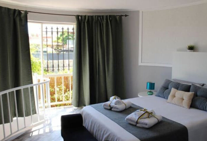 Pasion Tropical Gay Resort room in Playa del Ingles, Gran Canaria. Budget gay hotel with pool and gym. Bedroom with balcony and towels.