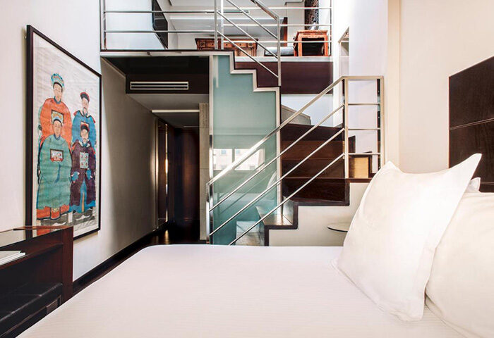 Urban Hotel Madrid artsy design room. Loft with stairs. Modern, luxury gay hotel. Asian art on wall. Best fun hotel for gay travel.