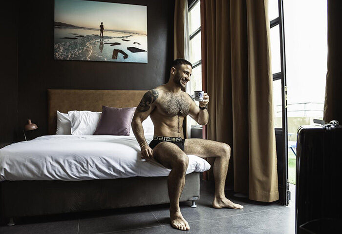 Man in underwear with coffee in a room at Inta Hotel, a gay adults-only accommodation in Tel Aviv-Jaffa. Best gay hotel with bar.