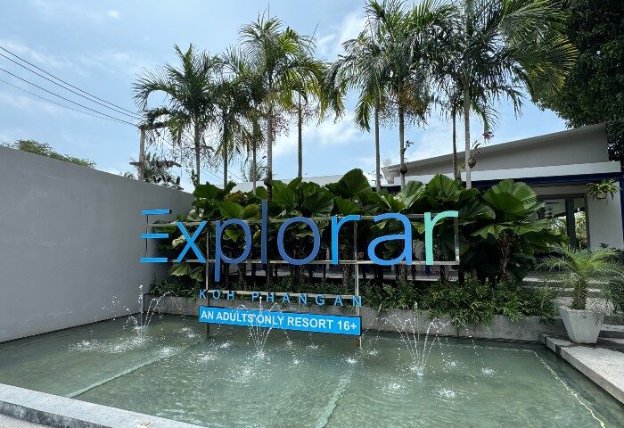 Explorar Koh Phangan, an adults-only resort and spa. Best gay beach hotel for big group of friends. Palm trees and water fountain.