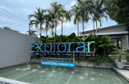 Explorar Koh Phangan, an adults-only resort and spa. Best gay beach hotel for big group of friends. Palm trees and water fountain.