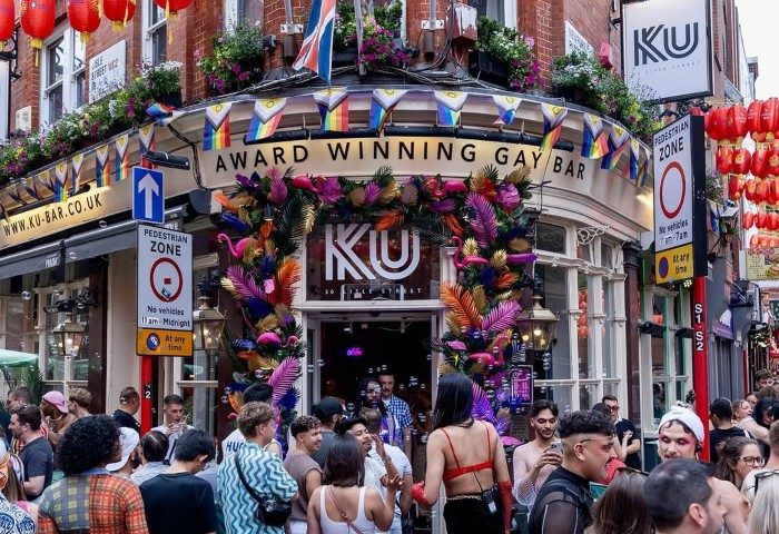 KU Bar/KU Club in London. Award-winning gay bar with rainbow flags, floral decorations, and a lively crowd. Best gay bar in London.