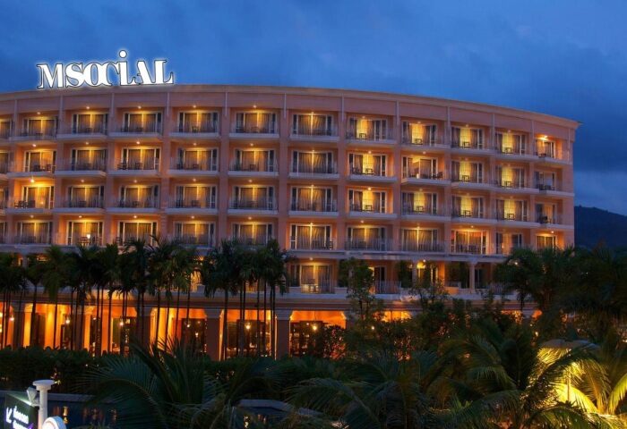 M Social Hotel Phuket: Exterior view of the gay-friendly beach hotel at dusk. A cheap price for a gay beach hotel in Phuket, Thailand.