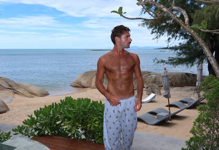 Gay beach hotspot, Rocky's Boutique Resort Samui. Man at Koh Samui's Veranda Collection, a gay-friendly resort with beach access, lounge chairs.