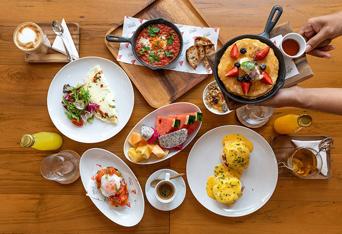 Outrigger Surin Beach Resort, Phuket: Delicious breakfast spread with pancakes, eggs benedict, fruit, and coffee. Best gay beach retreat hotel.