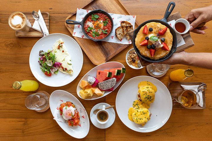 Outrigger Surin Beach Resort, Phuket: Delicious breakfast spread with pancakes, eggs benedict, fruit, and coffee. Best gay beach retreat hotel.