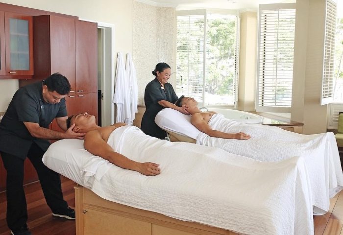 Gay couple getting massage at Moana Surfrider, A Westin Resort & Spa, Waikiki Beach. Best gay beach spa hotels Hawaii.