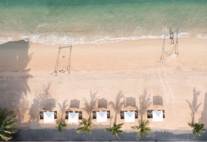Renaissance Pattaya Resort & Spa beachfront aerial view. Beach swings, cabanas, and palm trees. Best gay hotels in Pattaya, Thailand.