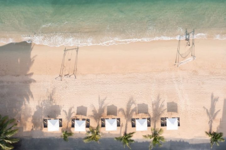 Renaissance Pattaya Resort & Spa beachfront aerial view. Beach swings, cabanas, and palm trees. Best gay hotels in Pattaya, Thailand.