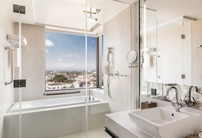 Chiang Mai Marriott Hotel bathroom. Modern design with bathtub, shower, sink, and large window overlooking the city. Best gay-friendly hotels.