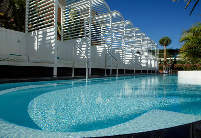 Gold Playa del Ingles Adults Only pool area. Best gay honeymoon hotel in Gran Canaria. White lounge cabanas line the pool.