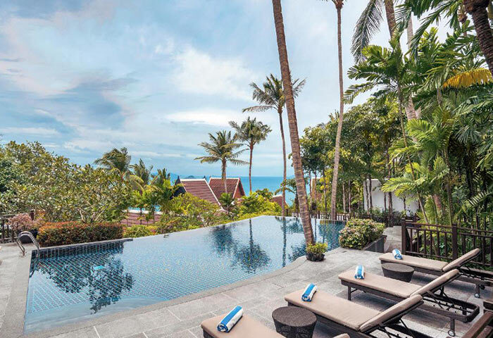 InterContinental Koh Samui Resort: Infinity pool, lounge chairs, and palm trees. Best gay honeymoon hotel in Koh Samui for gay travelers.