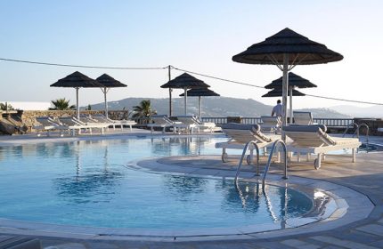 Hermes Mykonos Hotel pool view. Best gay honeymoon hotel in Mykonos Town gayborhood, Greece. Luxury travel for gay men. Sunbeds & umbrellas.