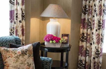 Les Tournelles hotel interior, best gay honeymoon hotel in Paris' gayborhood Marais. Lamp, flowers, curtains, pillows, table.