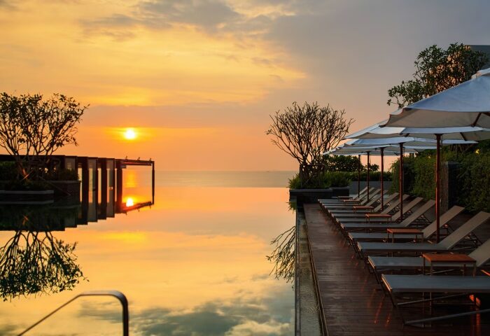 Sunset at Renaissance Pattaya Resort. Infinity pool, lounge chairs, and ocean view. Best gay honeymoon hotels. Thailand travel.