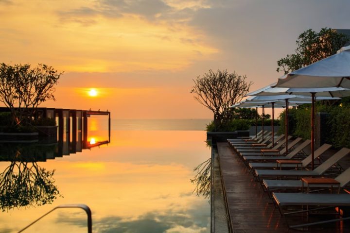 Sunset at Renaissance Pattaya Resort. Infinity pool, lounge chairs, and ocean view. Best gay honeymoon hotels. Thailand travel.