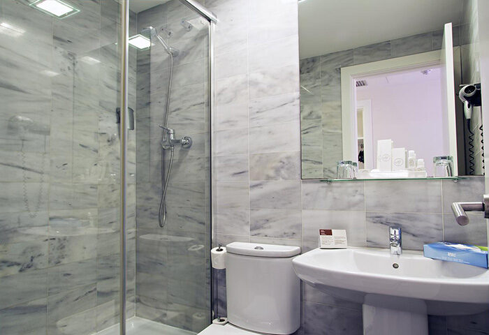 BCN Urbaness Hotels Del Comte bathroom. Walk distance to gay nightlife in Barcelona. Hotel room with shower, sink, and toilet.