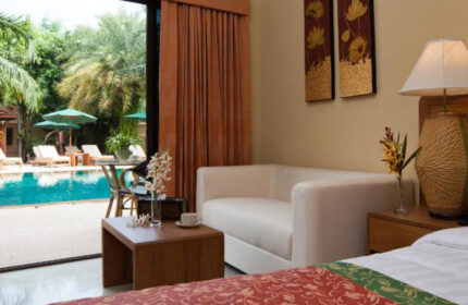 Baan Souy Resort, gay hotel Pattaya. Adults only room view of pool, lounge chairs, umbrellas. Best gay accommodations in Thailand.